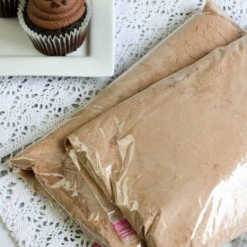 Tabletop of chocolate cake mix next to a plateful of chocolate cupcakes.