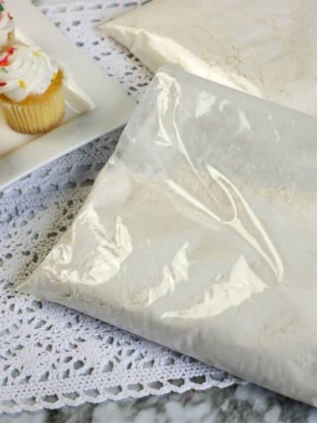 A bag of yellow cupcake mix with yellow cupcakes with white frosting.