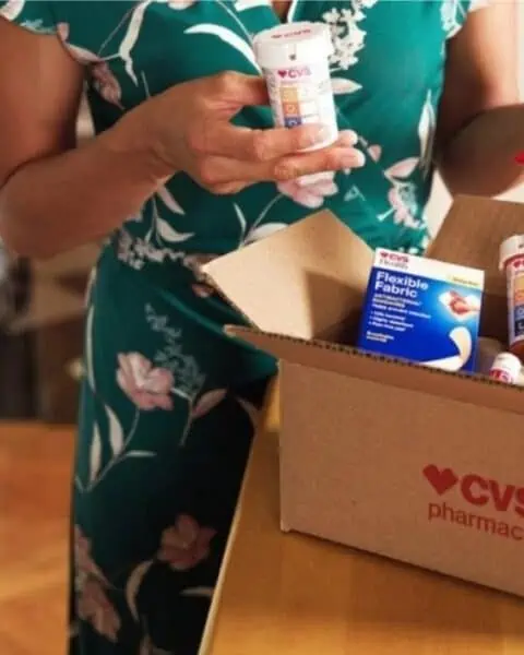 A woman opening a CVS pharmacy box of medical supplies.