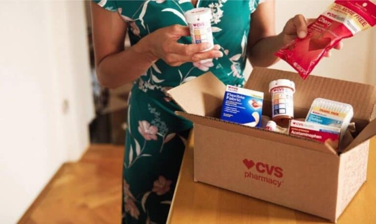 A woman opening a CVS pharmacy box of medical supplies.