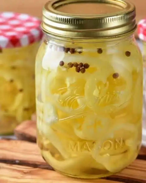 Pickled peppers with spices in mason jars.