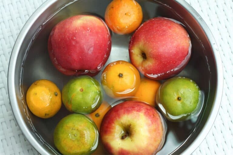 A water full bowl with apples, oranges, and other produces.