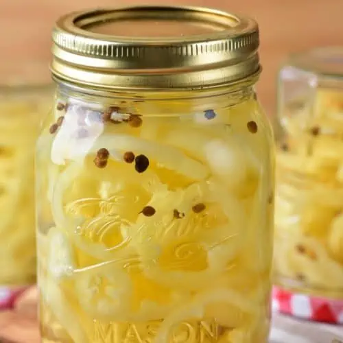 A mason jar with pickled banana peppers.