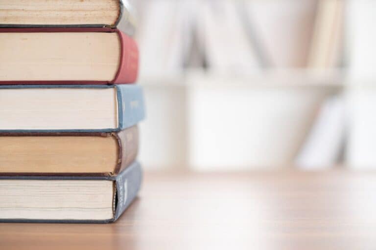 Stack of thick chapter books on a table.