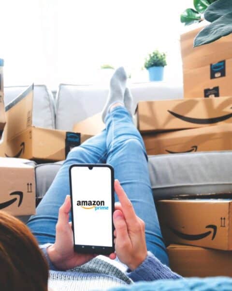 A woman on the Amazon app surrounded by packages and boxes from Amazon.