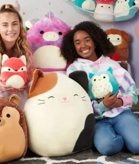 Two girls posing with stuffed animals in their bedroom, pleased with their new $20 free Walmart purchase.