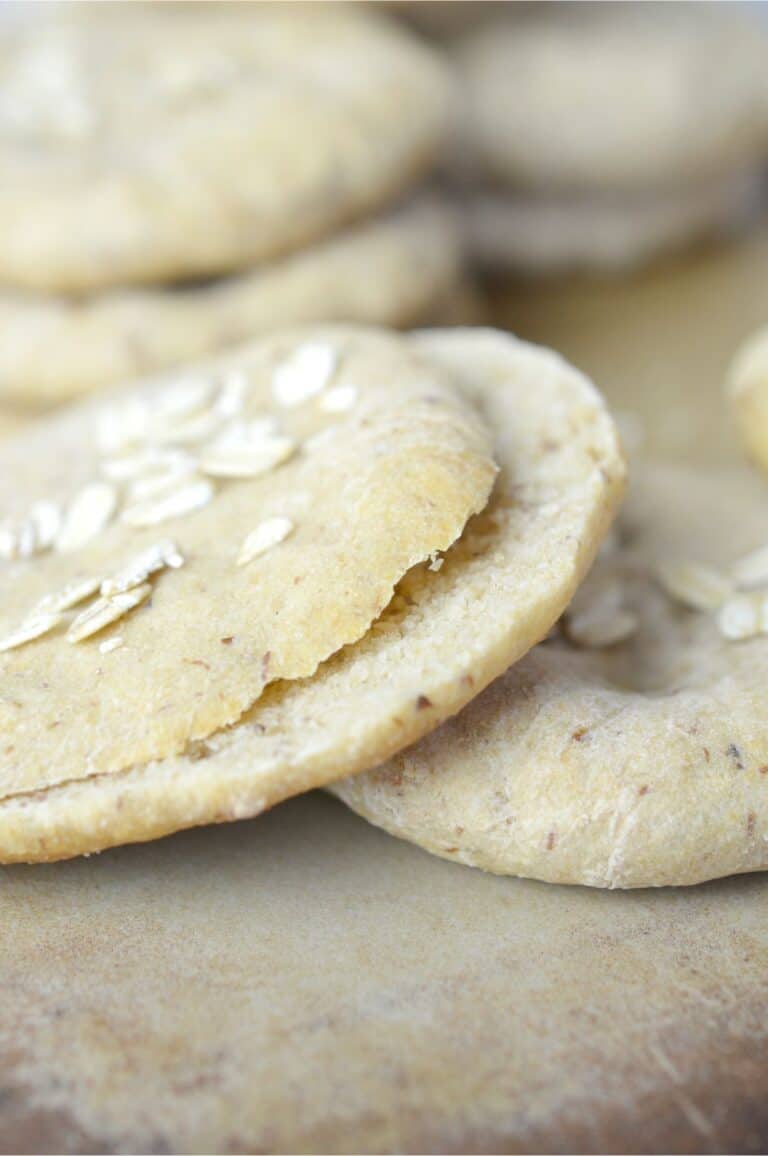 A stack of oat cookies on a cutting board, resembling a sandwich.