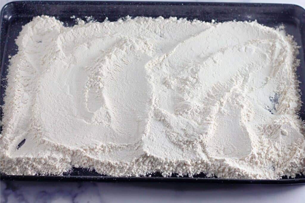 A baking sheet topped with edible chocolate chip cookie dough.