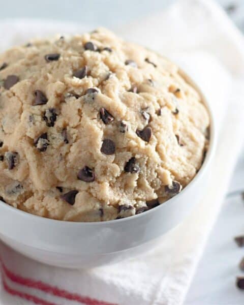 Edible chocolate chip cookie dough displayed in a white bowl.