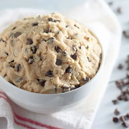 Edible chocolate chip cookie dough displayed in a white bowl.
