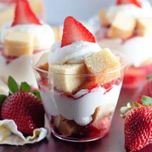 Strawberry shortcake cups topped with whipped cream and fresh strawberries.