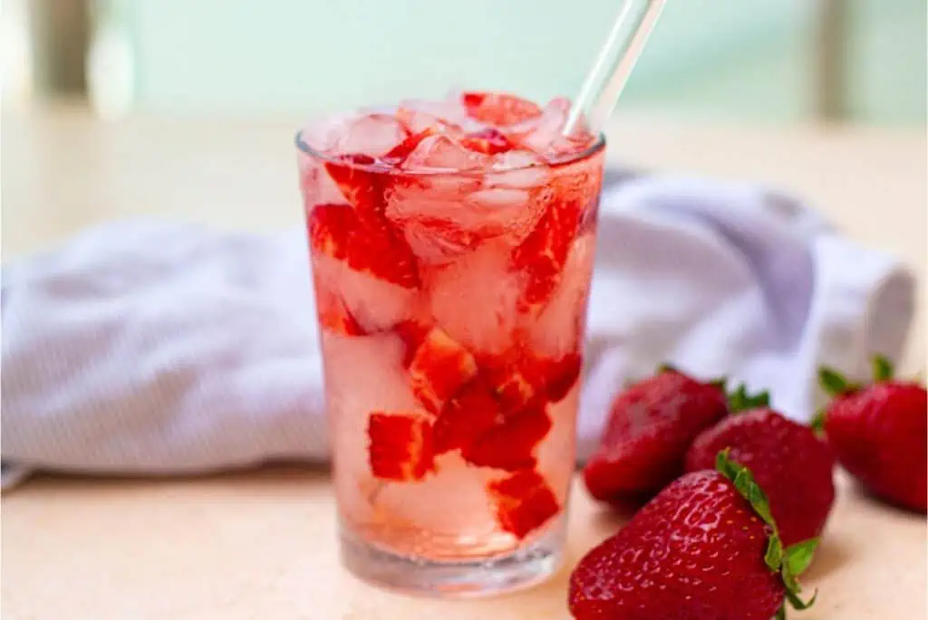 A refreshing Starbucks Strawberry Acai Refresher with ice and strawberries.