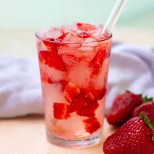 A refreshing Starbucks Strawberry Acai Refresher with ice and strawberries.