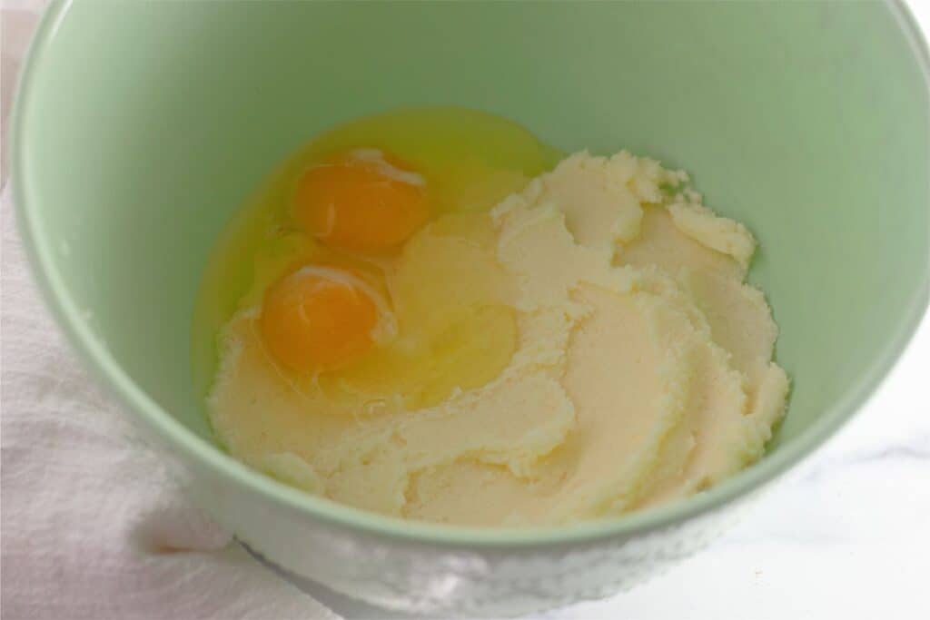 Two banana chocolate chip muffins with whipped cream.