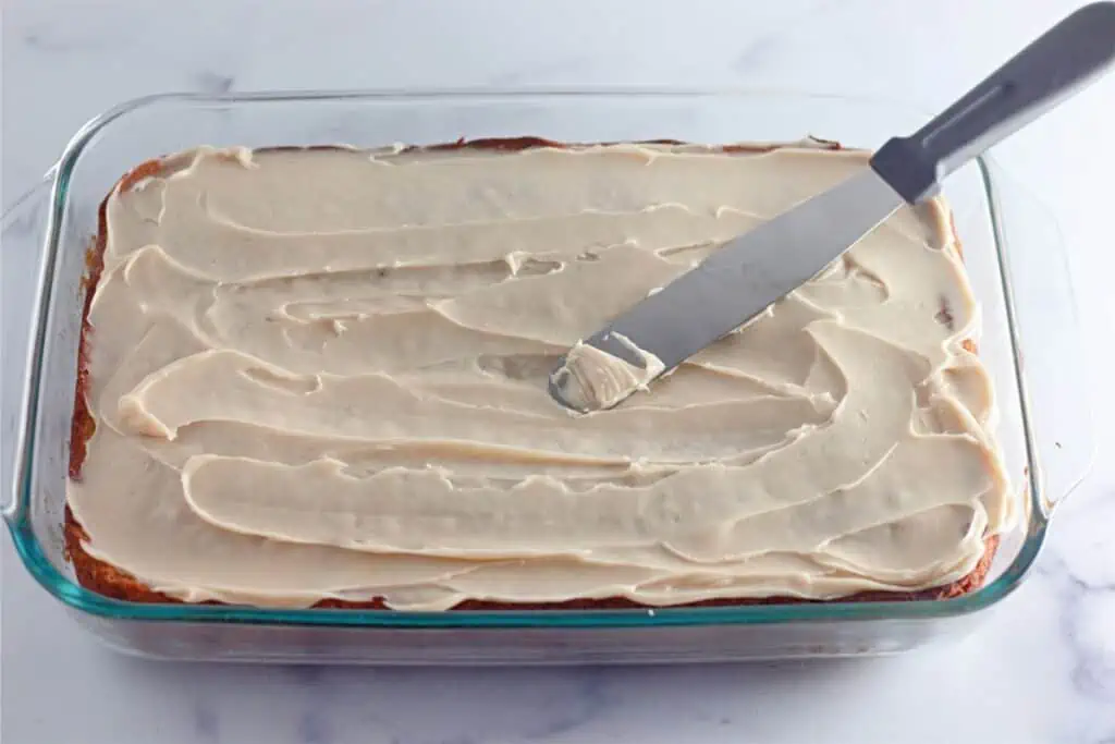 A glass baking dish with a knife in it, containing a classic Banana Coffee Cake.