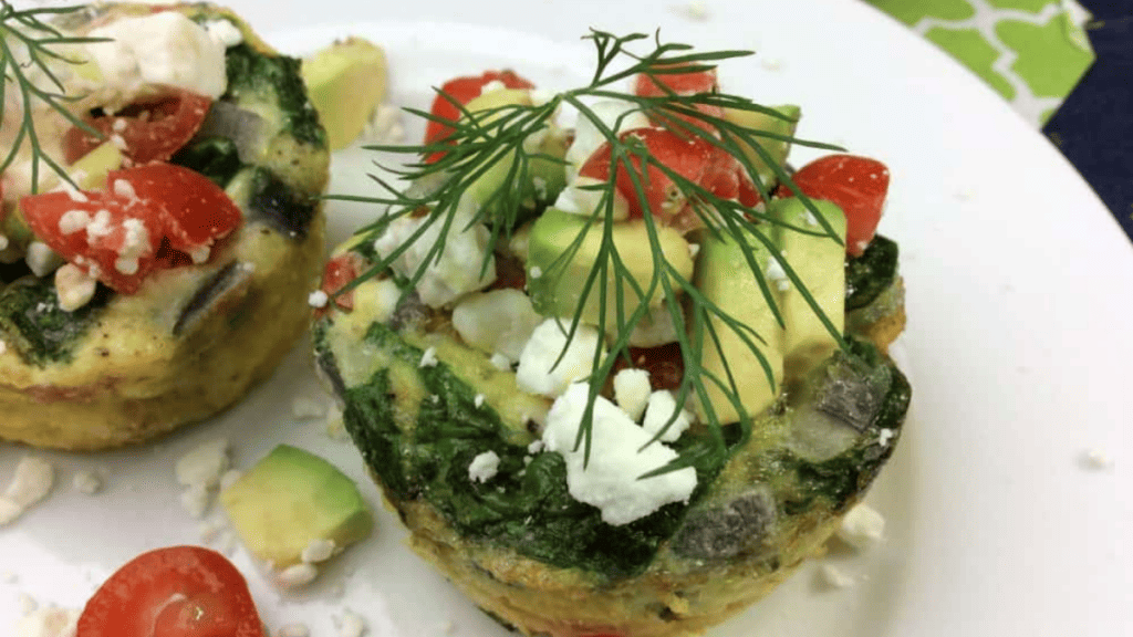 A plate of egg muffins with tomatoes and avocado.