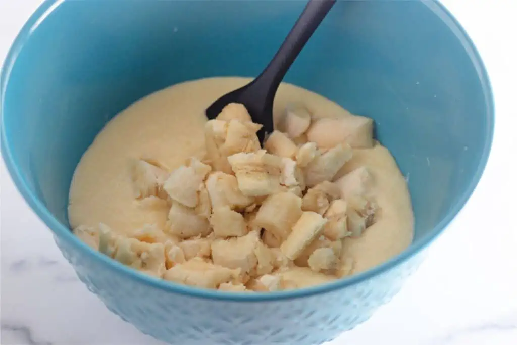 A blue bowl with mashed bananas, perfect for making banana coffee cake.