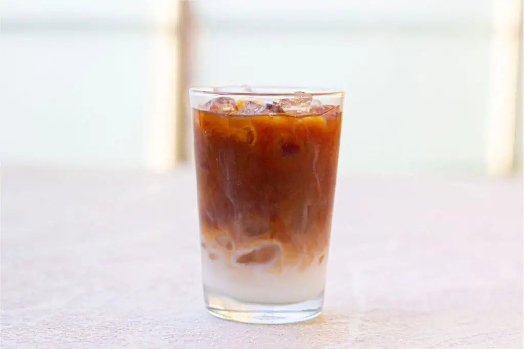 An iced Starbucks coffee with caramel on a table.