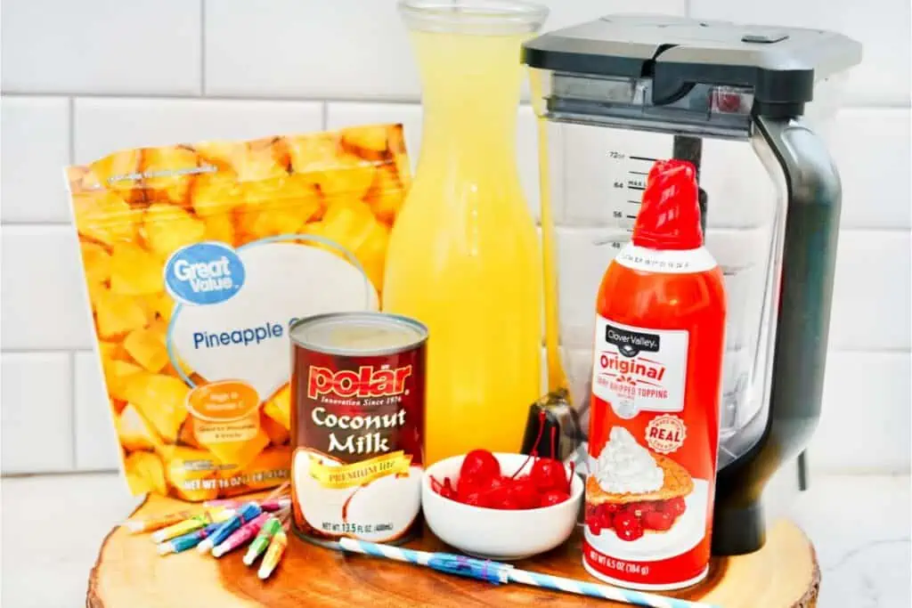 A cutting board with a blender preparing a Virgin Pina Colada recipe.