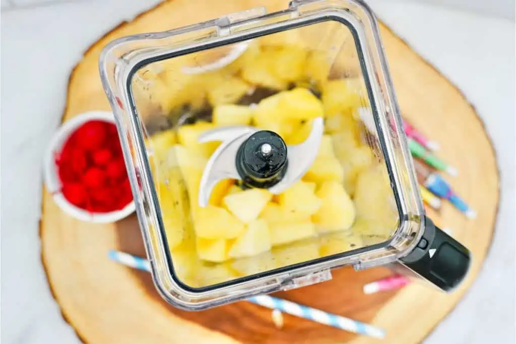 A blender filled with pineapples and other fruit for a Virgin Pina Colada Recipe.
