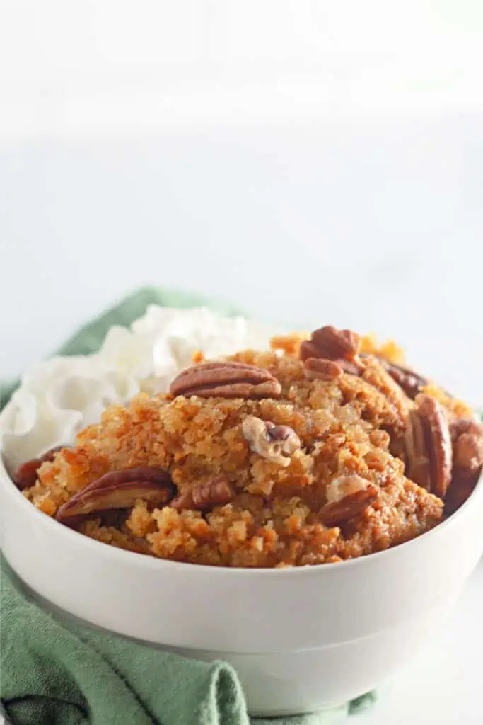 A Pumpkin Cobbler with whipped cream and pecans.