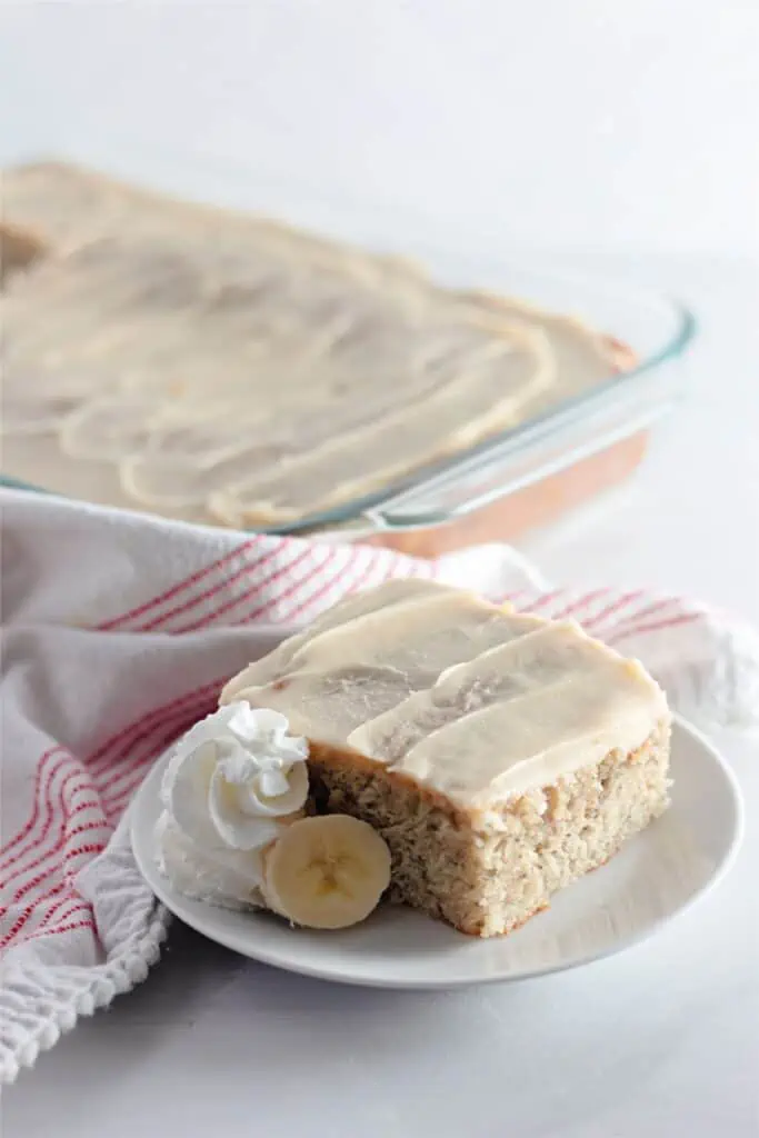 A slice of banana coffee cake with browned butter frosting on a plate.