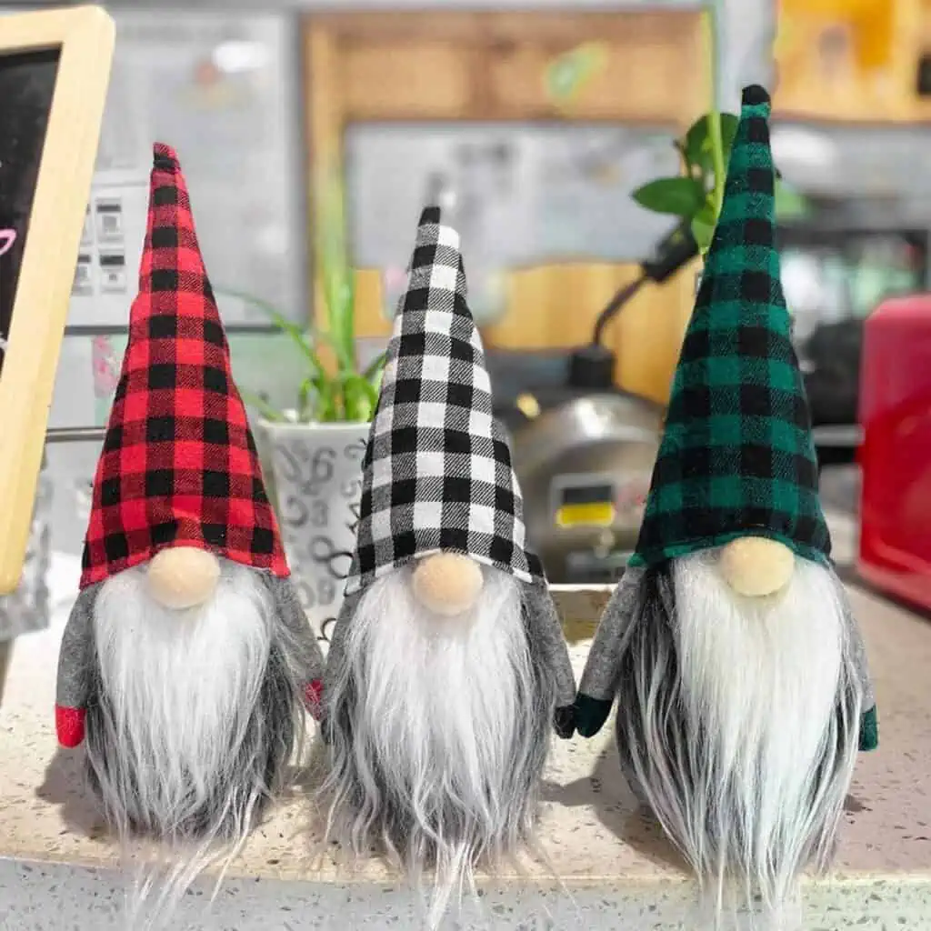 Three gnomes with plaid beards sitting on a counter, surrounded by enticing October 26th Deals.