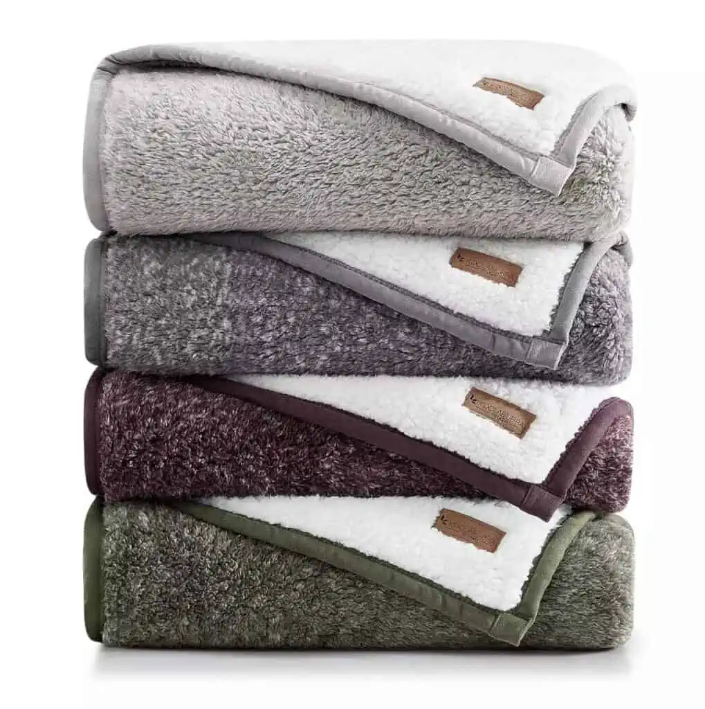 A stack of four different colored blankets on top of each other available for Deals through November 6th.