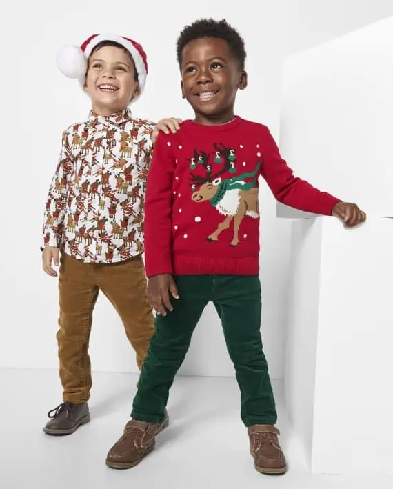 Two boys wearing Christmas sweaters and hats, participating in the November 27th Deals.