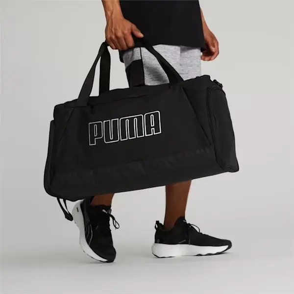 On November 27th, a man is carrying a black puma duffel bag as he searches for deals.