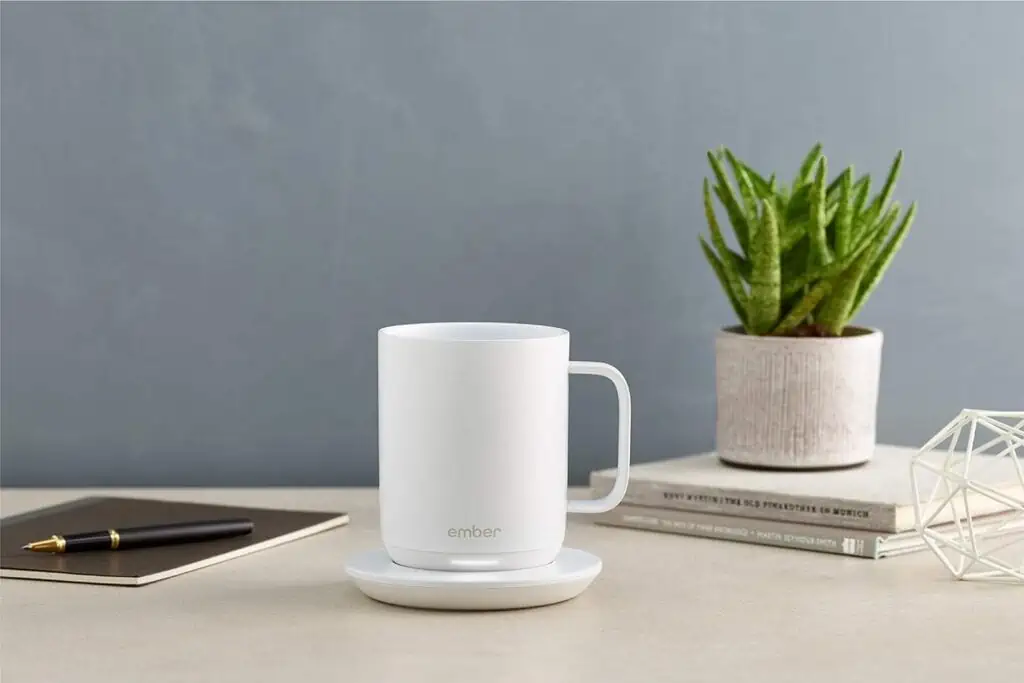 In preparation for the upcoming November 24th deals, a white coffee mug sits on a table next to a vibrant plant.