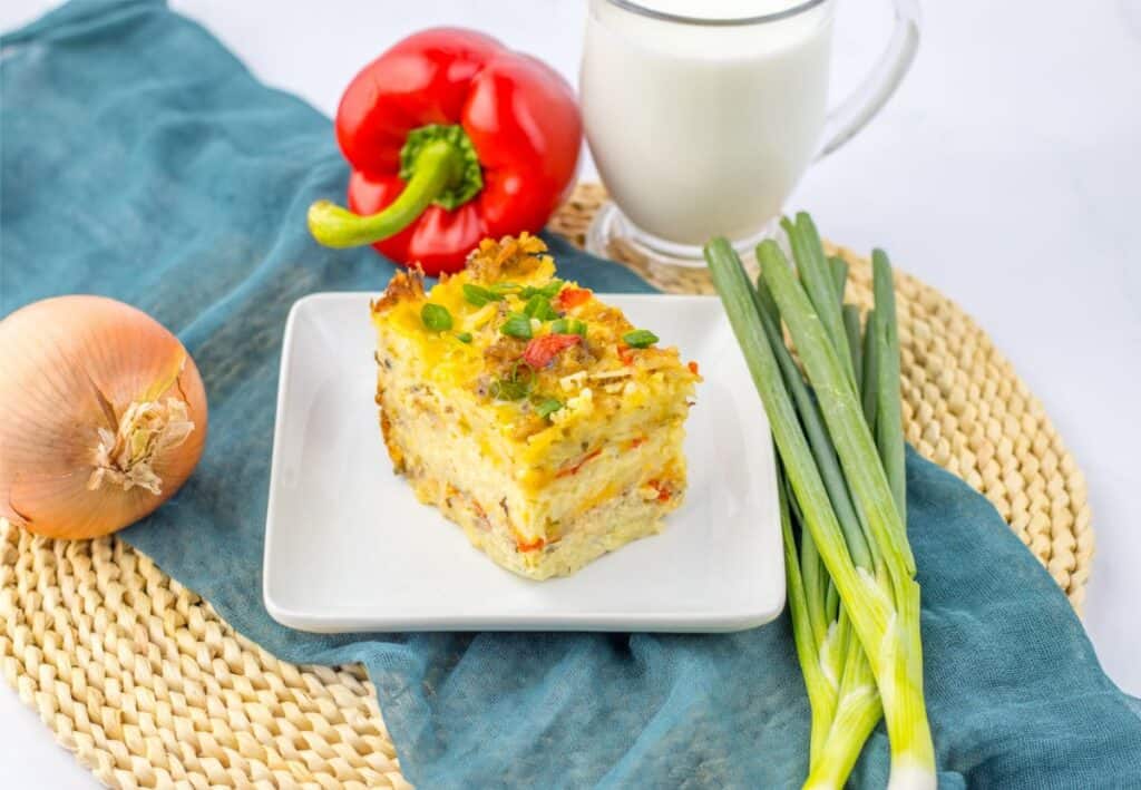 A delicious breakfast casserole prepared using a slow cooker, served on a plate with a side of milk.