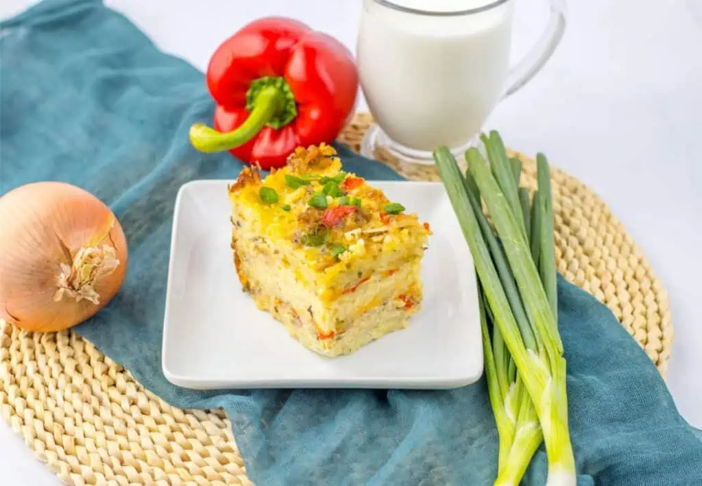 A delicious breakfast casserole prepared using a slow cooker, served on a plate with a side of milk.