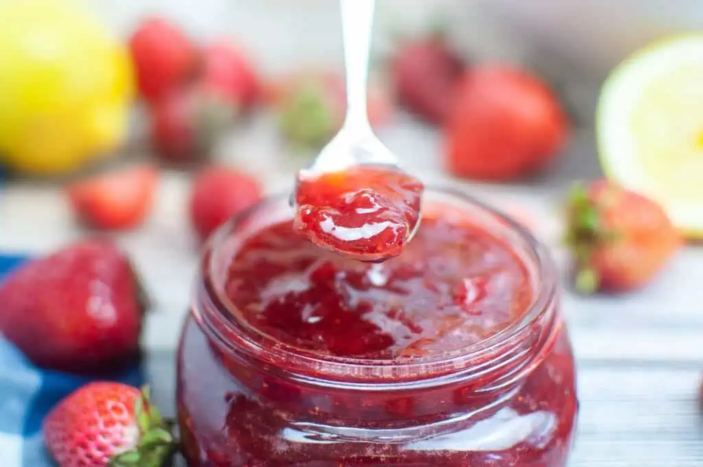 Strawberry jam recipe for canning, featuring strawberries in a jar.