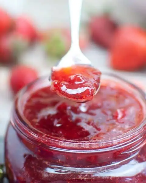 Strawberry jam recipe for canning, featuring strawberries in a jar.