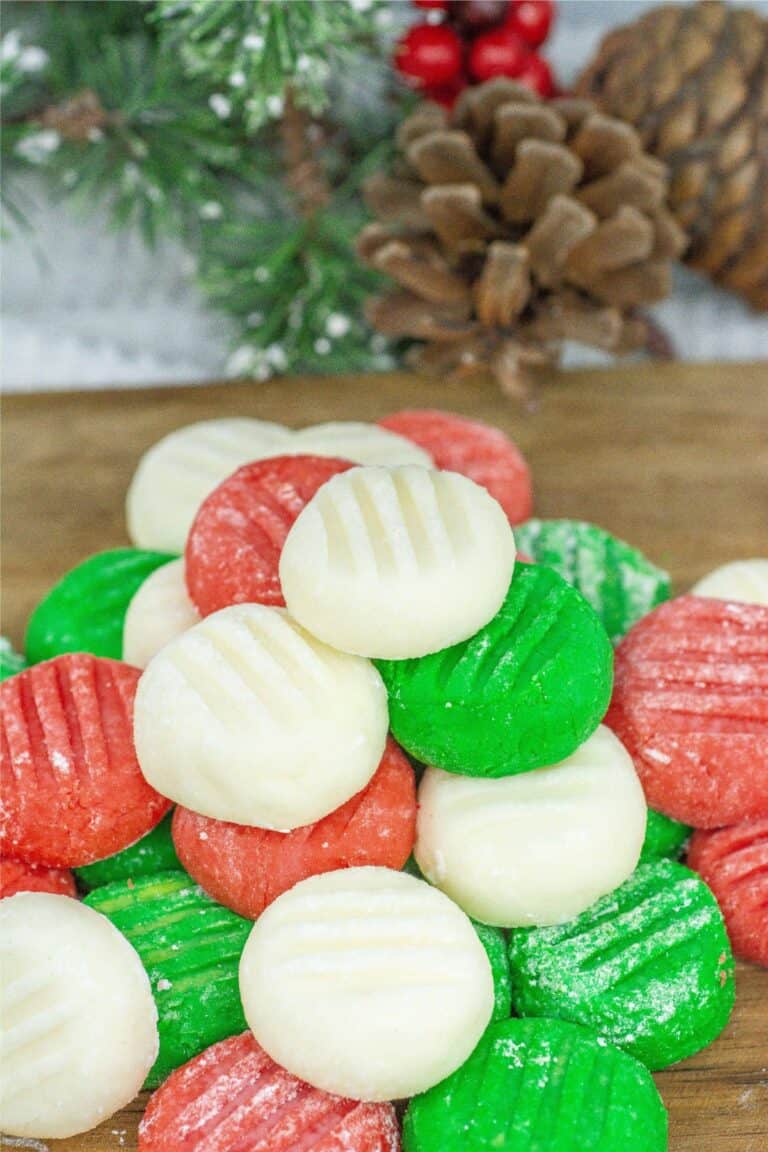 Homemade Christmas cookies on a cutting board with pine cones.