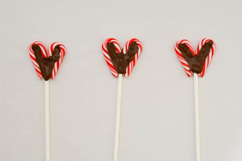 Three candy cane shaped lollipops on a stick, resembling reindeer antlers.