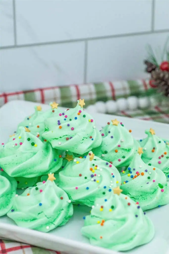 Meringue Christmas tree cookies on a white plate.