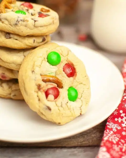 A stack of Christmas cookies on a plate, featuring an irresistible m&m cookie recipe.