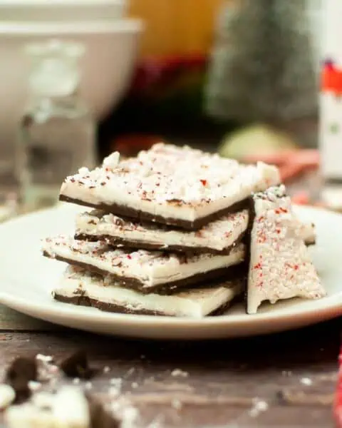 Peppermint bark on a plate with candy canes.