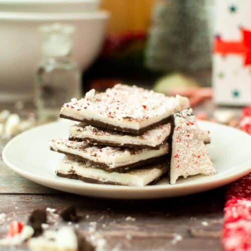 Peppermint bark on a plate with candy canes.
