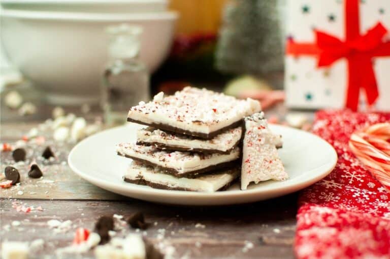 Peppermint bark on a plate with candy canes.