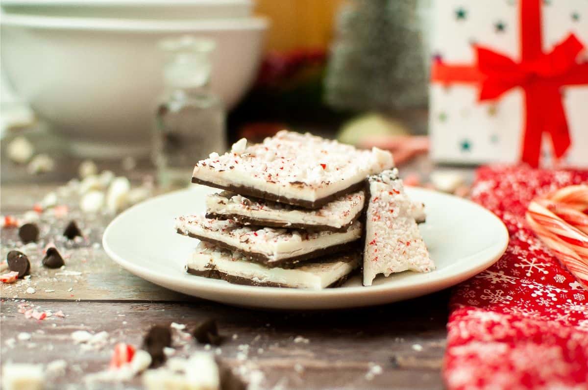 Peppermint bark on a plate with candy canes.
