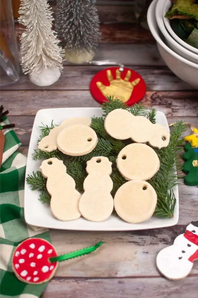 Beautiful homemade Christmas ornaments made of salt dough displayed on a plate.