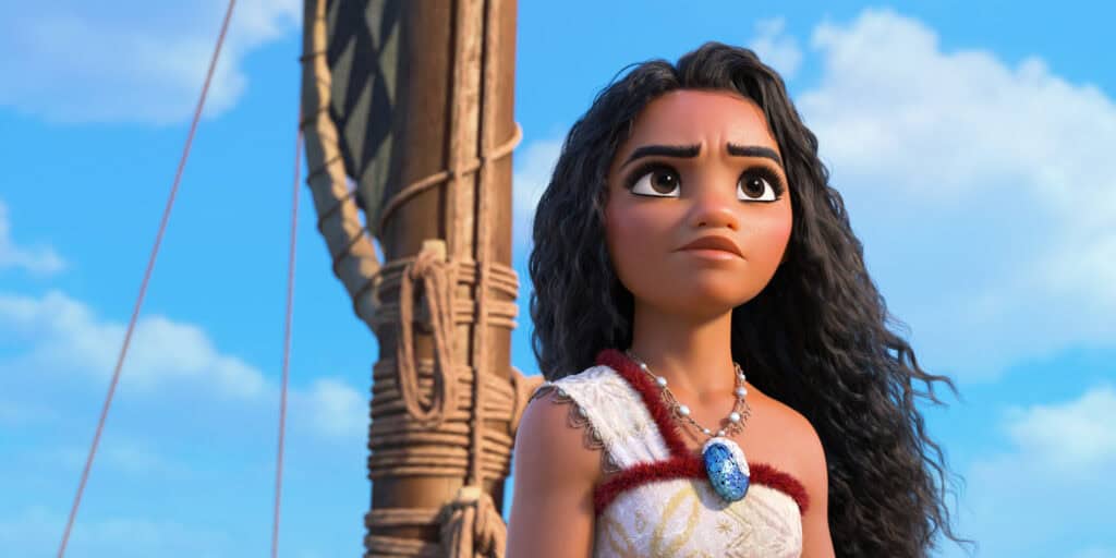 An animated character with long curly hair stands on a boat, wearing a patterned top and necklace with a blue pendant, gazing into the distance under a blue sky. Experience this adventure and more for just $1.99 per month on Disney Plus.