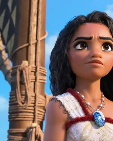 An animated character with long curly hair stands on a boat, wearing a patterned top and necklace with a blue pendant, gazing into the distance under a blue sky. Experience this adventure and more for just $1.99 per month on Disney Plus.