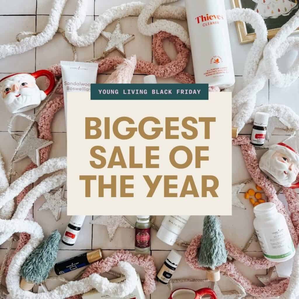 A flat lay of skincare, essential oils, Christmas decor, and garlands surrounds a sign reading "Young Living Black Friday Deals: Biggest Sale of the Year.