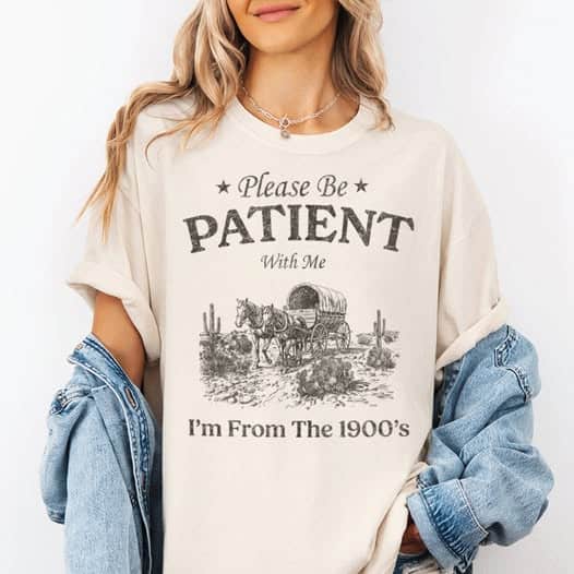 A person sports a T-shirt with the text: "Please Be Patient With Me I'm From The 1900's," alongside a covered wagon graphic, capturing an old-world charm reminiscent of a visit to the Bavarian Inn.