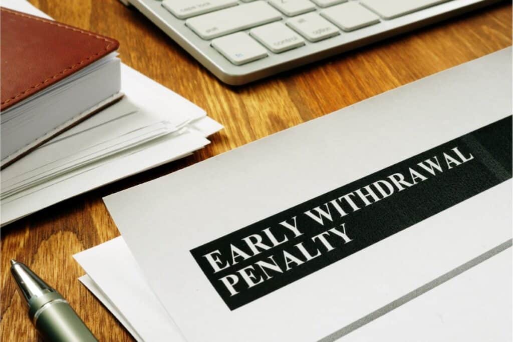 A document titled "Early Withdrawal Penalty" lies on a wooden desk, offering crucial financial advice. It's surrounded by a keyboard, a stack of papers, a notebook, and a pen—tools essential for retirement planning and understanding your 401K options.