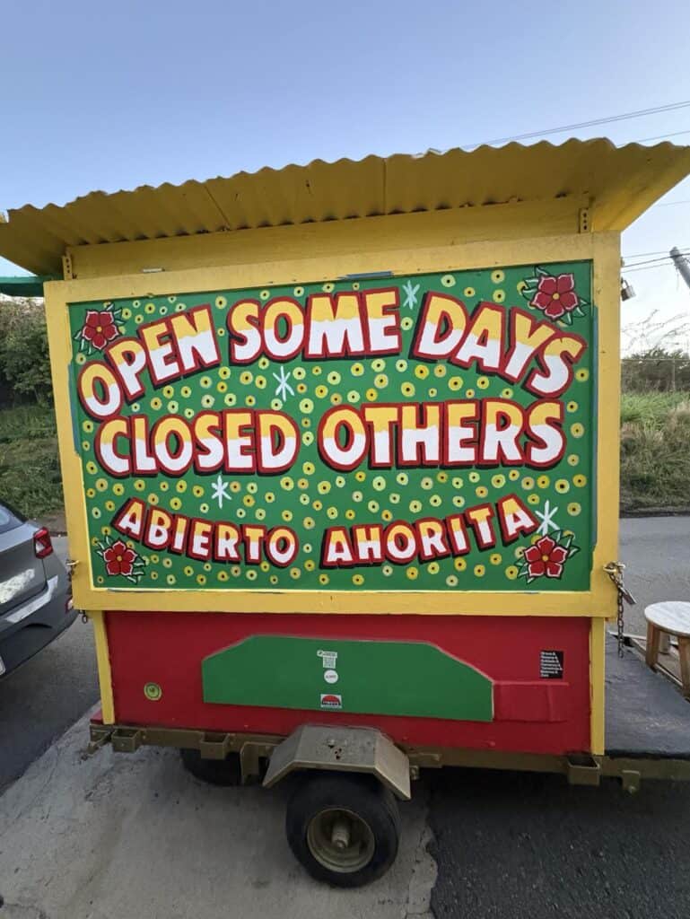 Brightly colored food cart with bold text: "Open Some Days, Closed Others. Abierto Ahorita." Perfect for shaking off the post-vacation blues or taking a break from your to-do list.